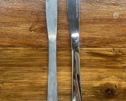 قاشق و چنگالهای استیل در حال خیس خوردن در محلول طبیعی آب گرم و سرکه سفید برای ضدعفونی.